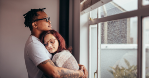Casal se abraçando com expressão de acolhimento emocional