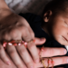 Bebê dormindo durante a regressão do sono, com mãos adultas oferecendo conforto e acolhimento